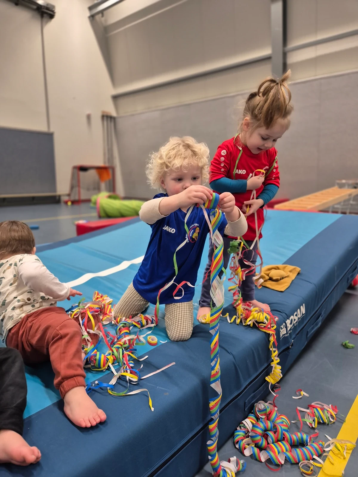 Kinderen spelen samen met kleurrijke linten tijdens een kampje